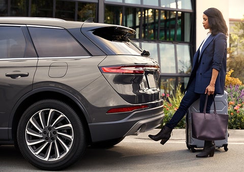 A woman with her hands full uses her foot to activate the available hands-free liftgate. | Vision Lincoln in Wahpeton ND