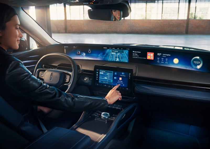 The driver of a 2024 Lincoln Nautilus® SUV interacts with the center touchscreen. | Vision Lincoln in Wahpeton ND